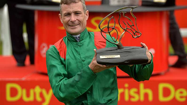 25 June 2016; Pat Smullen celebrates with the trophy after winning the Dubai Duty Free Irish Derby on Harzand at the Curragh Racecourse in the Curragh, Co. Kildare. Photo by Cody Glenn/Sportsfile