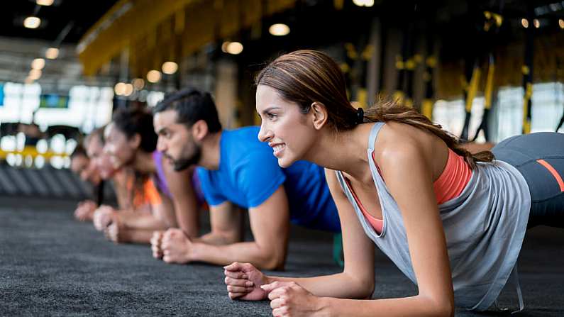 Group of people exercising at the gym in a suspension training class a?? fitness concepts