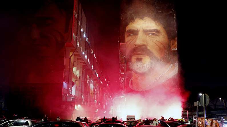 People light flares as they gather under a mural depicting soccer legend Diego Maradona, in Naples, Italy, Wednesday, Nov. 25, 2020. Diego Maradona has died. The Argentine soccer great was among the best players ever and who led his country to the 1986 World Cup title before later struggling with cocaine use and obesity. He was 60. (Fabio Sasso/LaPresse via AP)