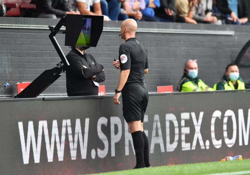 Referee Anthony Taylor checks the monitor