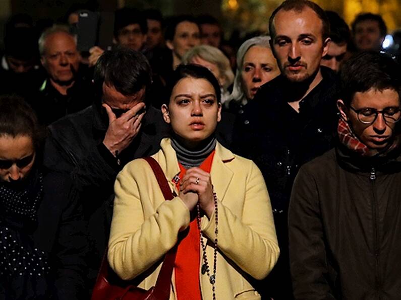 Parisians kneel and sing as they watch their beautiful Notre Dame Cathedral burn