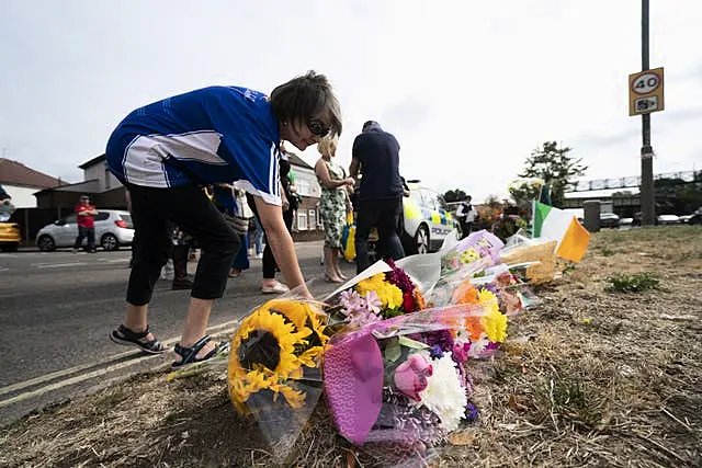 A woman lays flowers in memory of Mr O'Halloran 