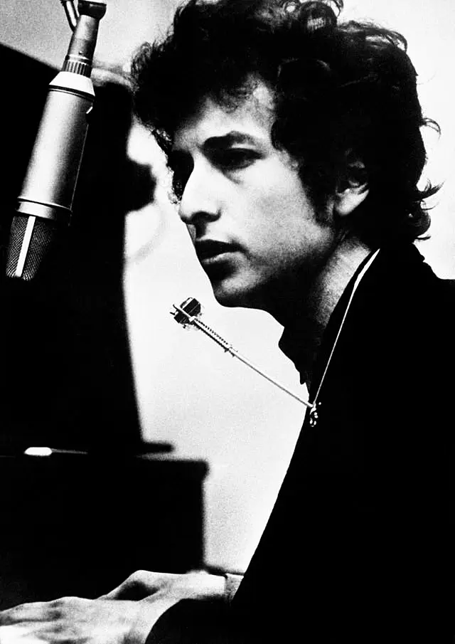 Singer Bob Dylan at his piano in black and white