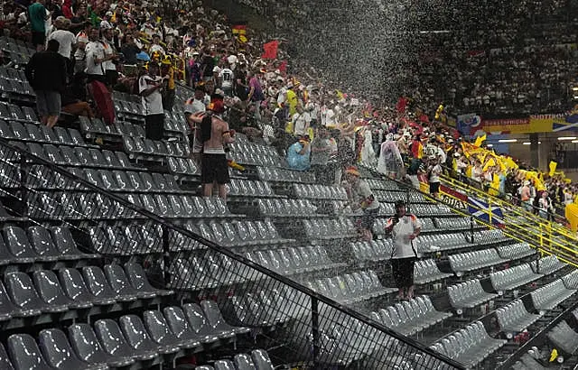 Fans shelter from the rain during the 24-minute delay