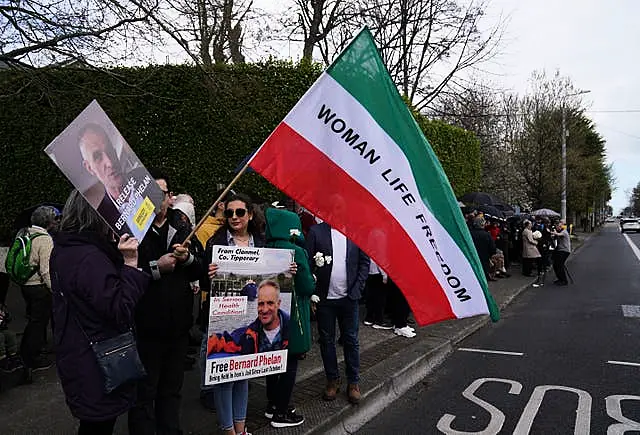 People attend a vigil for Bernard Phelan outside the Iranian Embassy in Dublin