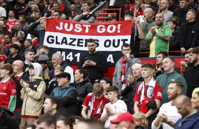 Manchester United fans hold up a banner protesting against the Glazers