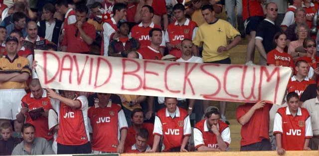 Arsenal fans hold a banner referring to Manchester United’s David Beckham
