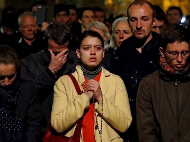 Parisians kneel and sing as they watch their beautiful Notre Dame Cathedral burn