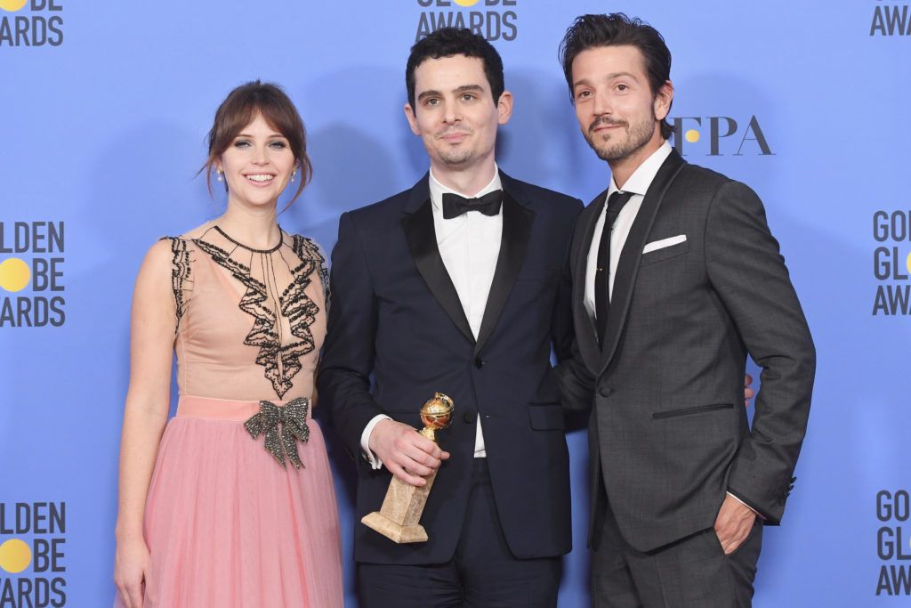 BEVERLY HILLS, CA - JANUARY 08:  Writer/director Damien Chazelle (C), winner of Best Screenplay for 'La La Land,' poses in the press room with actors Felicity Jones (L) and Diego Luna (R) during the 74th Annual Golden Globe Awards at The Beverly Hilton Hotel on January 8, 2017 in Beverly Hills, California.  (Photo by Kevin Winter/Getty Images)