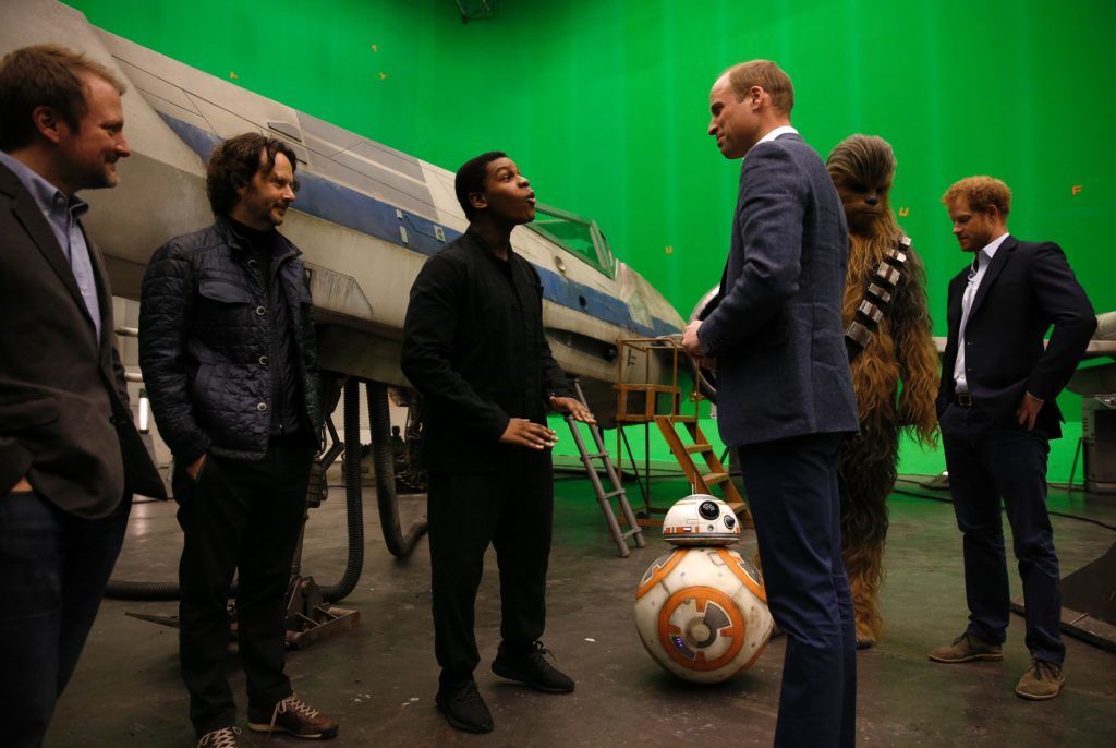 Britain's Prince William, Duke of Cambridge speaks with British actor John Boyega (C) and Episode VIII director Rian Johnson (2L) during a visit to the Star Wars film set at Pinewood Studios near Iver Heath, west of London April 19, 2016.   
(Photo ADRIAN DENNIS/AFP/Getty Images)