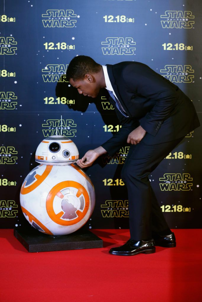 John Boyega touches BB-8 at the 'Star Wars: The Force Awakens' fan event at the Roppongi Hills on December 10, 2015 in Tokyo, Japan.  (Photo by Christopher Jue/Getty Images for Walt Disney Studios)