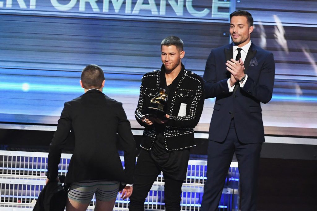 LOS ANGELES, CA - FEBRUARY 12:  Recording artist Nick Jonas (C) presents the the Best Pop Duo/Group Performance award for 'Stressed Out' to recording artist Tyler Joseph (L) of music group Twenty One Pilots onstage during The 59th GRAMMY Awards at STAPLES Center on February 12, 2017 in Los Angeles, California.  (Photo by Kevin Winter/Getty Images for NARAS)
