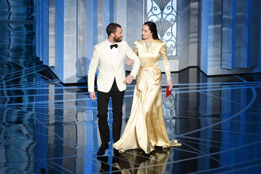 HOLLYWOOD, CA - FEBRUARY 26:  Actors Jamie Dornan (L) and Dakota Johnson speak onstage during the 89th Annual Academy Awards at Hollywood & Highland Center on February 26, 2017 in Hollywood, California.  (Photo by Kevin Winter/Getty Images)