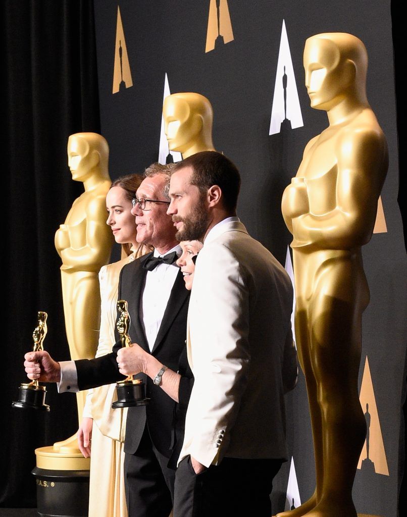 HOLLYWOOD, CA - FEBRUARY 26:  Production designer David Wasco (2nd from L) and set decorator Sandy Reynolds-Wasco (2nd from R), winners of the award for Production Design for 'La La Land,' pose with presenters Dakota Johnson (L) and Jamie Dornan in the press room during the 89th Annual Academy Awards at Hollywood & Highland Center on February 26, 2017 in Hollywood, California.  (Photo by Kevork Djansezian/Getty Images)