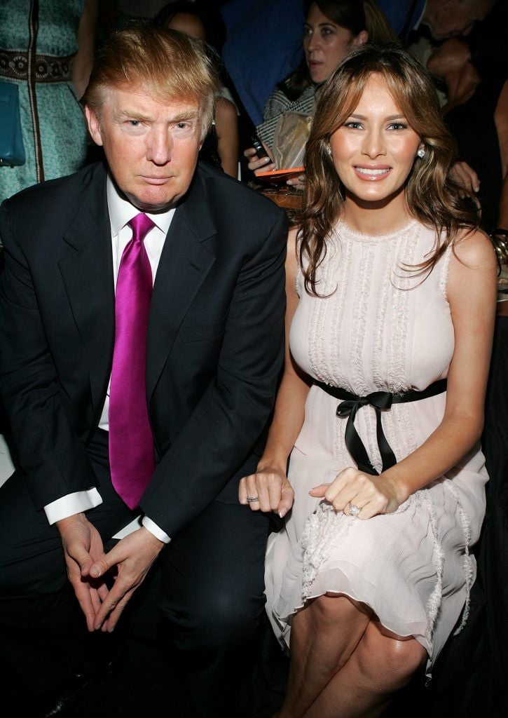 Donald Trump and his wife Melania Trump pose in the front row at the Oscar De La Renta Spring 2006 fashion show during Olympus Fashion Week at Bryant Park September 12, 2005 in New York City.  (Photo by Thos Robinson/Getty Images)