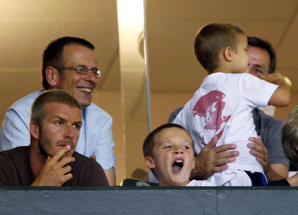 David Beckham and his son Brooklyn watch the SuperLiga match between Los Angeles Galaxy and Pachuca at The Home Depot Centre on July 24, 2007 in Carson, United States. Radio presenter and journalist Tom Watt is seen behind Beckham.  (Photo by Shaun Botterill/Getty Images)