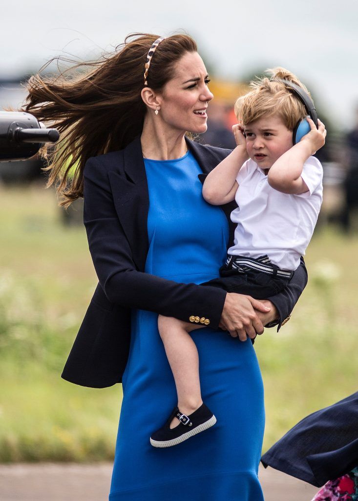 Britain's Prince George (R) wears ear defenders as he visits the Royal International Air Tattoo at RAF Fairford in western England on July 8, 2016, with his mother Catherine, Duchess of Cambridge, (L) and his father Prince William. (Photo by RICHARD POHLE/AFP/Getty Images)