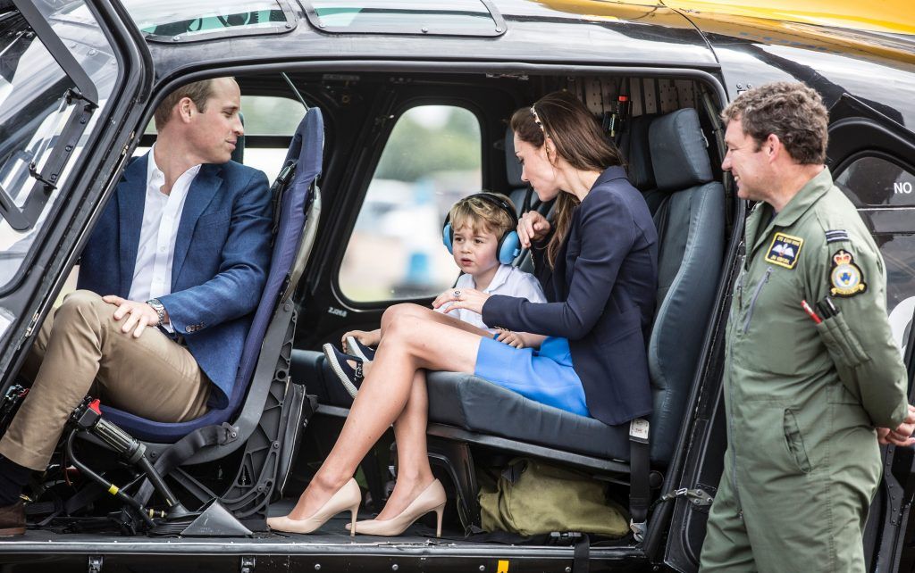 Britain's Prince George (2nd L) sits in a 'Squirrel' helicopter with his mother Catherine, Duchess of Cambridge and father Prince William during a visit to the Royal International Air Tattoo at RAF Fairford in western England, on July 8, 2016.  (Photo by RICHARD POHLE/AFP/Getty Images)