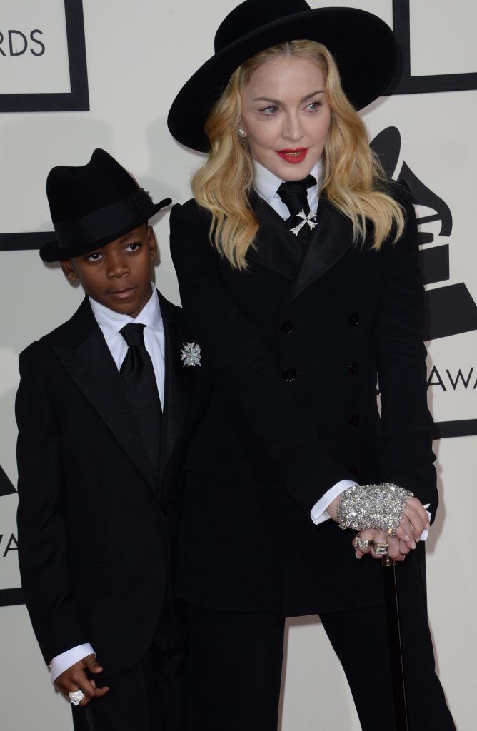 Performer Madonna poses on the red carpet with David Banda during the 56th Grammy Awards at the Staples Center in Los Angeles, California, January 26, 2014.       (Photo by ROBYN BECK/AFP/Getty Images)