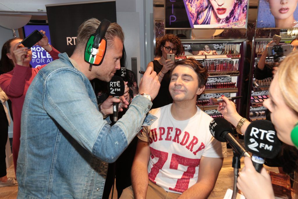 RTE 2FM'S 'The Nicky Byrne Show with Jenny Green' presenters Nicky Byrne and Jenny Greengets to work on  Carl Mullen as they broadcast live from the new Urban Decay Boutique in Grafton Street Dublin. Picture by Brian McEvoy