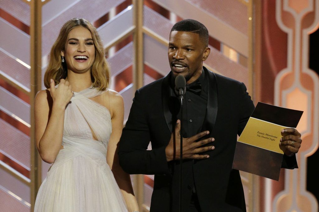 Lily James and Jamie Foxx onstage during the 73rd Annual Golden Globe Awards at The Beverly Hilton Hotel on January 10, 2016 in Beverly Hills, California.  (Photo by Paul Drinkwater/NBCUniversal via Getty Images)