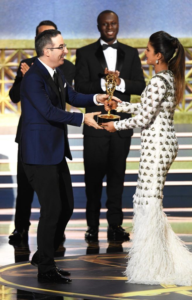 LOS ANGELES, CA - SEPTEMBER 17:  TV personality John Oliver (L) accepts Outstanding Variety Talk Series for 'Last Week Tonight with John Oliver' from actor Priyanka Chopra onstage during the 69th Annual Primetime Emmy Awards at Microsoft Theater on September 17, 2017 in Los Angeles, California.  (Photo by Kevin Winter/Getty Images)