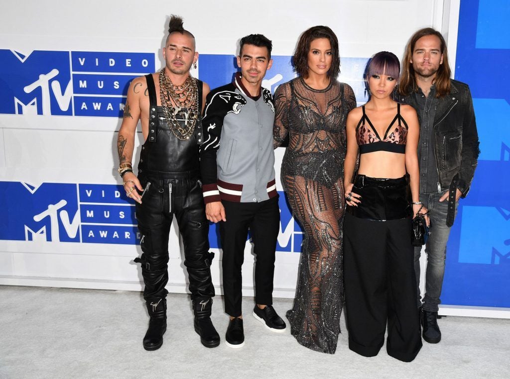 Cole Whittle (L), Joe Jonas (2nd L), JinJoo Lee (2nd R), Jack Lawless (R) of DNCE with Ashley Graham (C) arrive for the 2016 MTV Video Music Awards August 28, 2016 at Madison Square Garden in New York. / AFP / angela weiss        (Photo credit should read ANGELA WEISS/AFP/Getty Images)