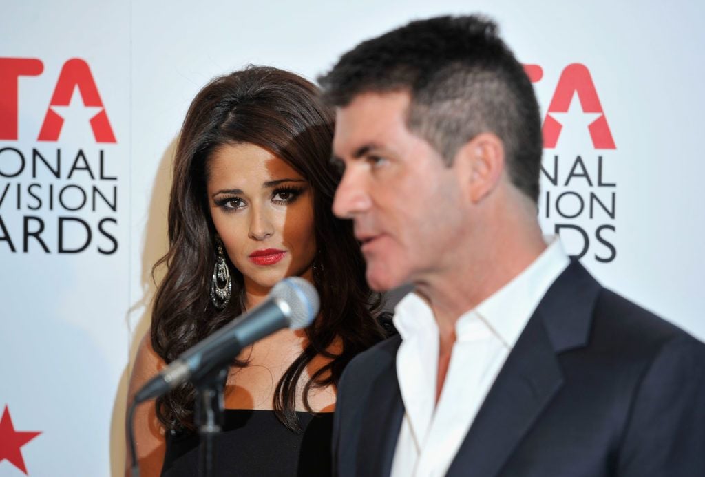 Cheryl and Simon Cowell speak after they win the Most Popular Talent Show for The X Factor during the National Television Awards at the O2 Arena on January 26, 2011 in London, England. (Photo by Gareth Cattermole/Getty Images)