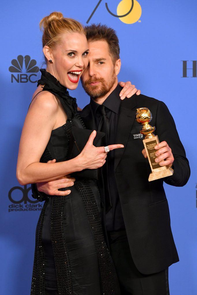 BEVERLY HILLS, CA - JANUARY 07:  Leslie Bibb poses with actor Sam Rockwell holding his award for Best Performance by an Actor in a Supporting Role in any Motion Picture for 'Three Billboards Outside Ebbing, Missouri' in the press room during The 75th Annual Golden Globe Awards at The Beverly Hilton Hotel on January 7, 2018 in Beverly Hills, California.  (Photo by Kevin Winter/Getty Images)