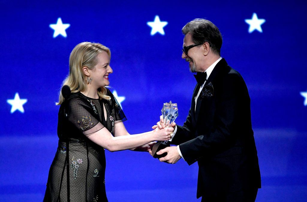 Actor Gary Oldman (R) accepts Best Actor for 'Darkest Hour' from actor Elisabeth Moss onstage during The 23rd Annual Critics' Choice Awards at Barker Hangar on January 11, 2018 in Santa Monica, California.  (Photo by Kevin Winter/Getty Images)