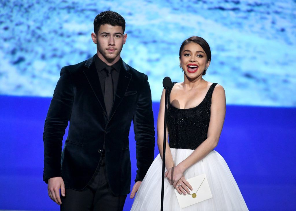 Actor/singer Nick Jonas and actor Sarah Hyland speak onstage during The 23rd Annual Critics' Choice Awards at Barker Hangar on January 11, 2018 in Santa Monica, California.  (Photo by Kevin Winter/Getty Images)