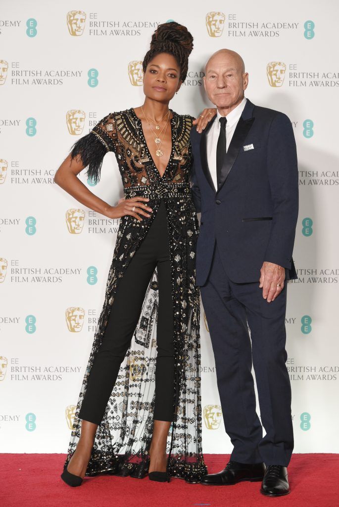Naomie Harris (L) and Sir Patrick Stewart pose in the press room during the EE British Academy Film Awards (BAFTA) held at Royal Albert Hall on February 18, 2018 in London, England.  (Photo by David M. Benett/Dave Benett/Getty Images)