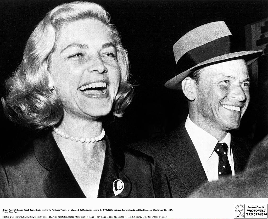 Shown from left: Lauren Bacall, Frank Sinatra leaving the Pantages Theater in Hollywood, California after viewing the TV fight film between Carmen Basilio and Ray Robinson.  (September 26, 1957)


WENN.com
