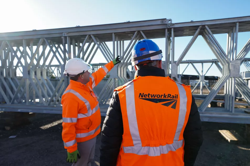 The Ukrainian engineer talking to a Network Rail worker (left) by the fast-assemble bridge they built over two weeks of training in England. (Jacob King/PA Wire)