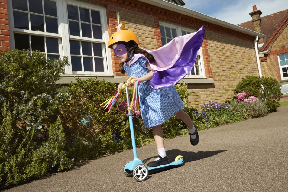 Girl riding a scooter to school