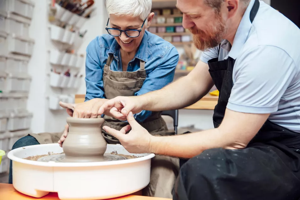 A man and woman doing a pottery class