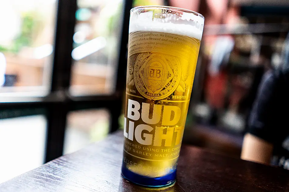 Bud Light in a branded glass on a bar top