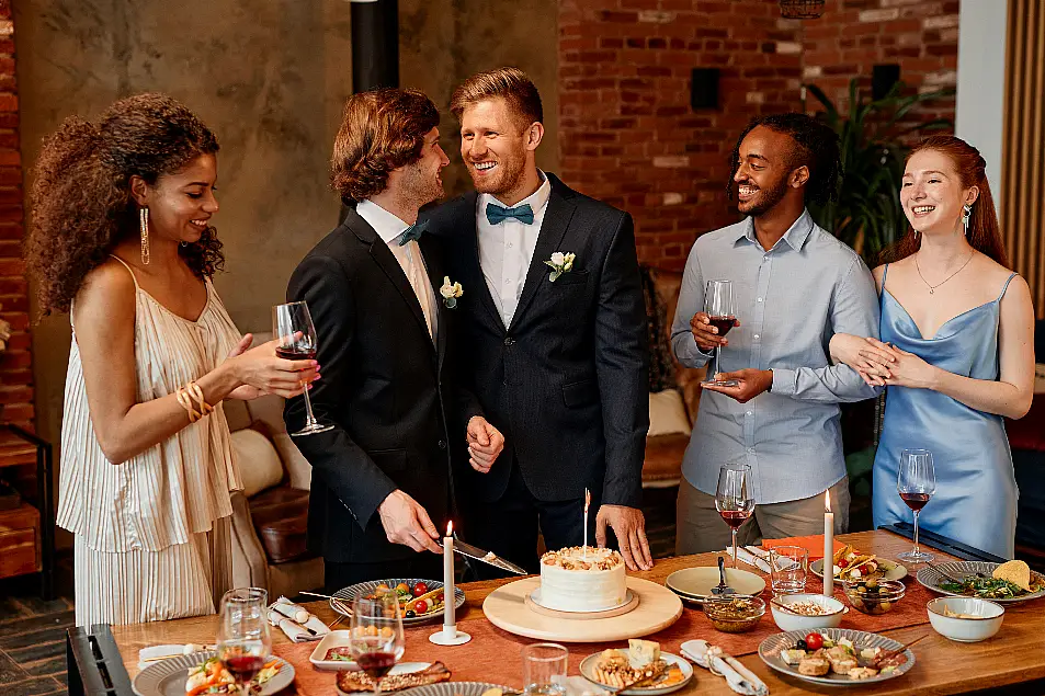 gay couple smiling happily while celebrating at wedding reception