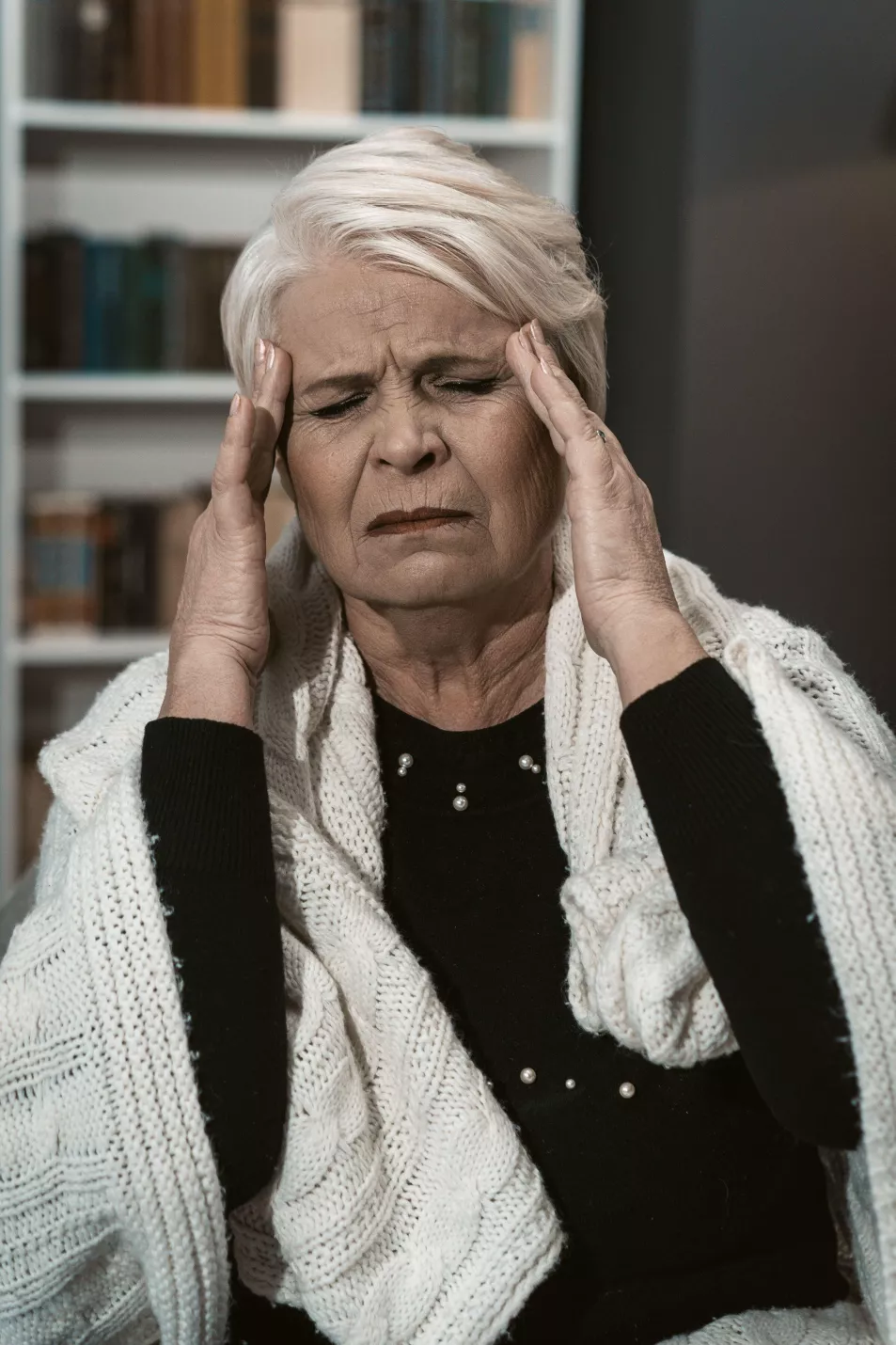 woman with headache holds her head