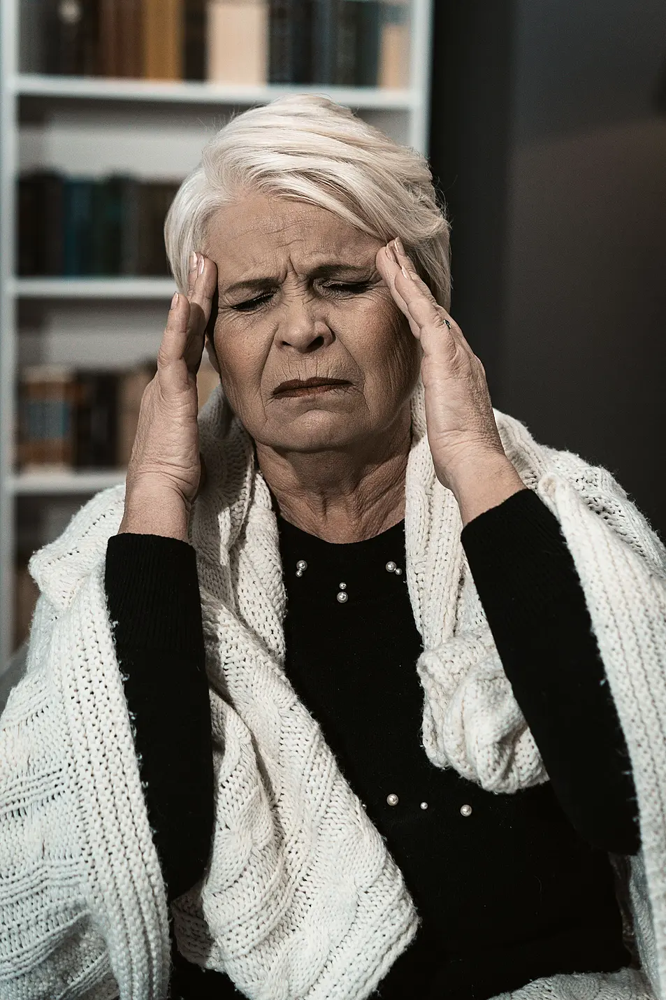 woman with headache holds her head