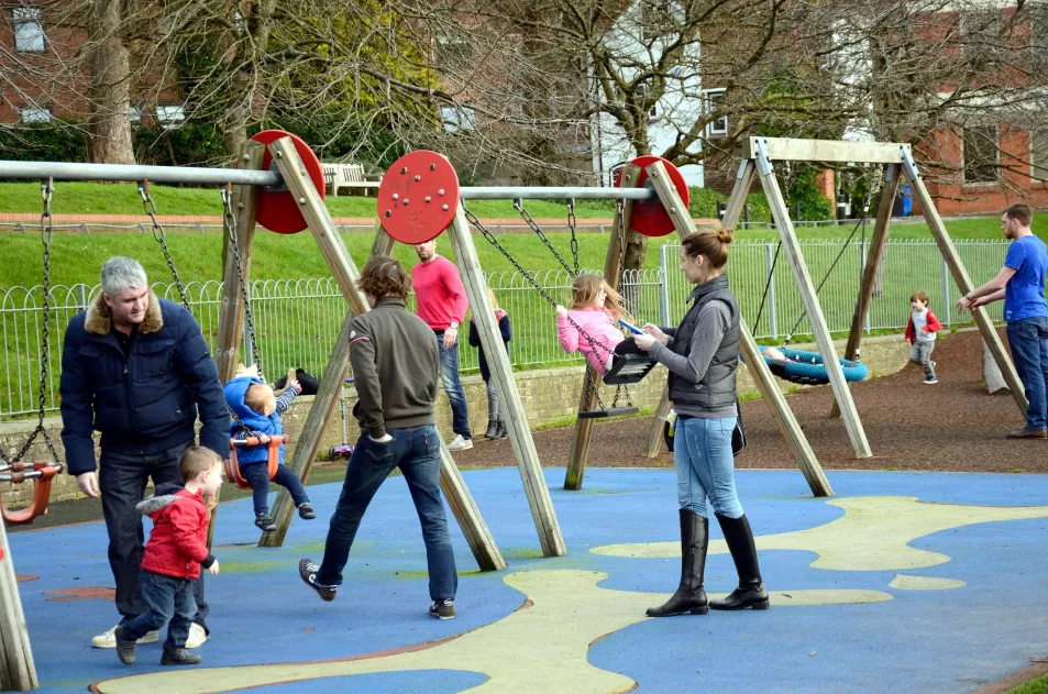 Children in a playground with their parents