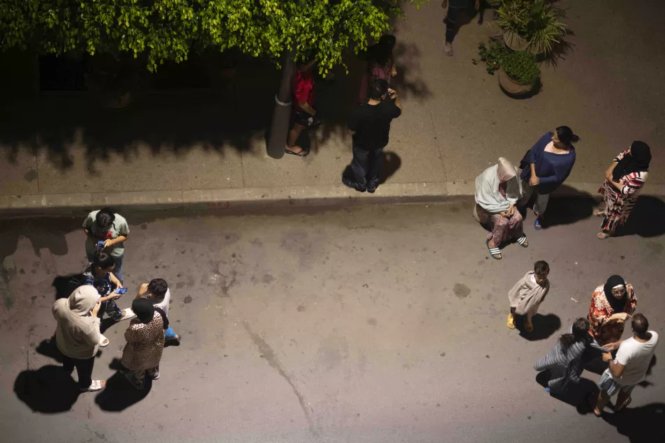 Pessoas se abrigam e verificam notícias em seus celulares após terremoto em Rabat