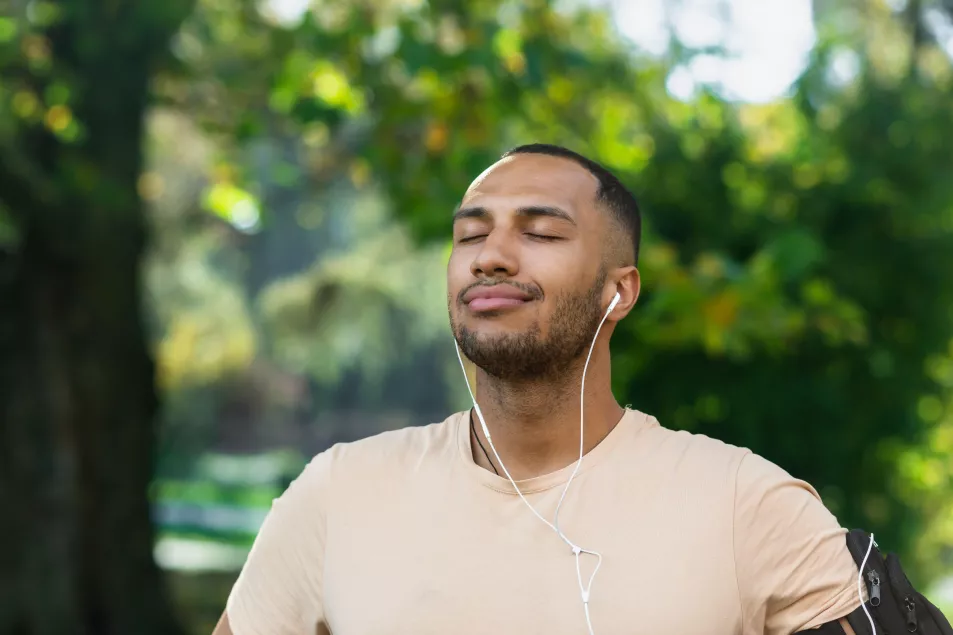 Man outside in nature taking some deep breaths