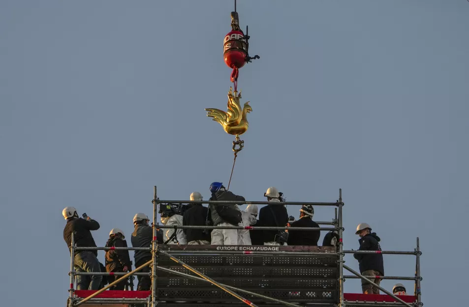 The rooster is lowered onto the cathedral's spire