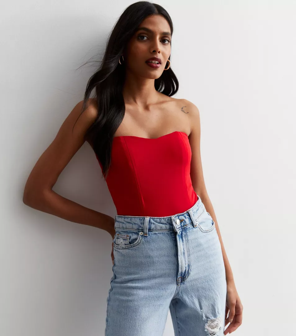 New Look Red Bandeau Corset Bodysuit, £8 (was £21.99); Blue Ripped Knee High Waist Tori Mom Jeans, £32.99