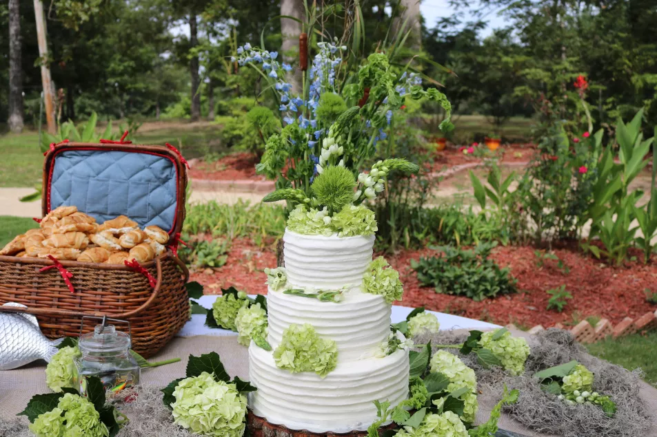 Outdoor wedding cake with green floral accents