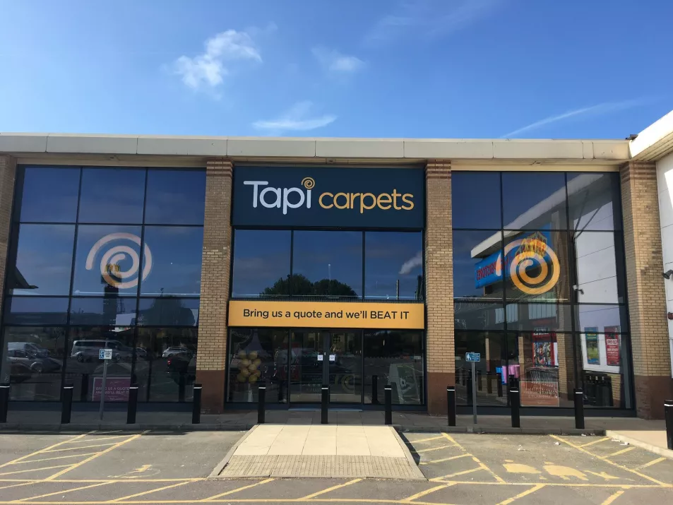 A glass-fronted store with Tapi Carpets logo