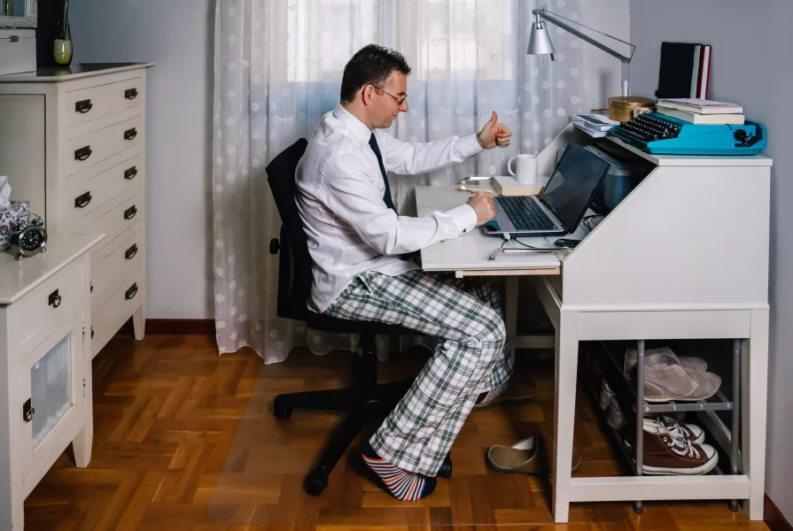 A man homeworking in pyjamas
