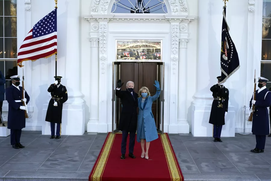President Joe Biden and first lady Jill Biden wave as they arrive at the North Portico of the White House 