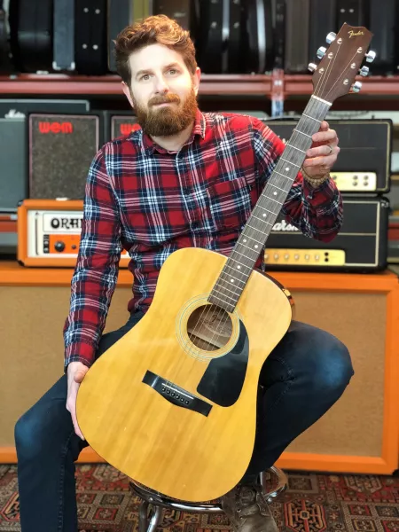 Auctioneer Luke Hobbs with Prince's Fender Gemini II guitar (Gardiner Houlgate/PA).